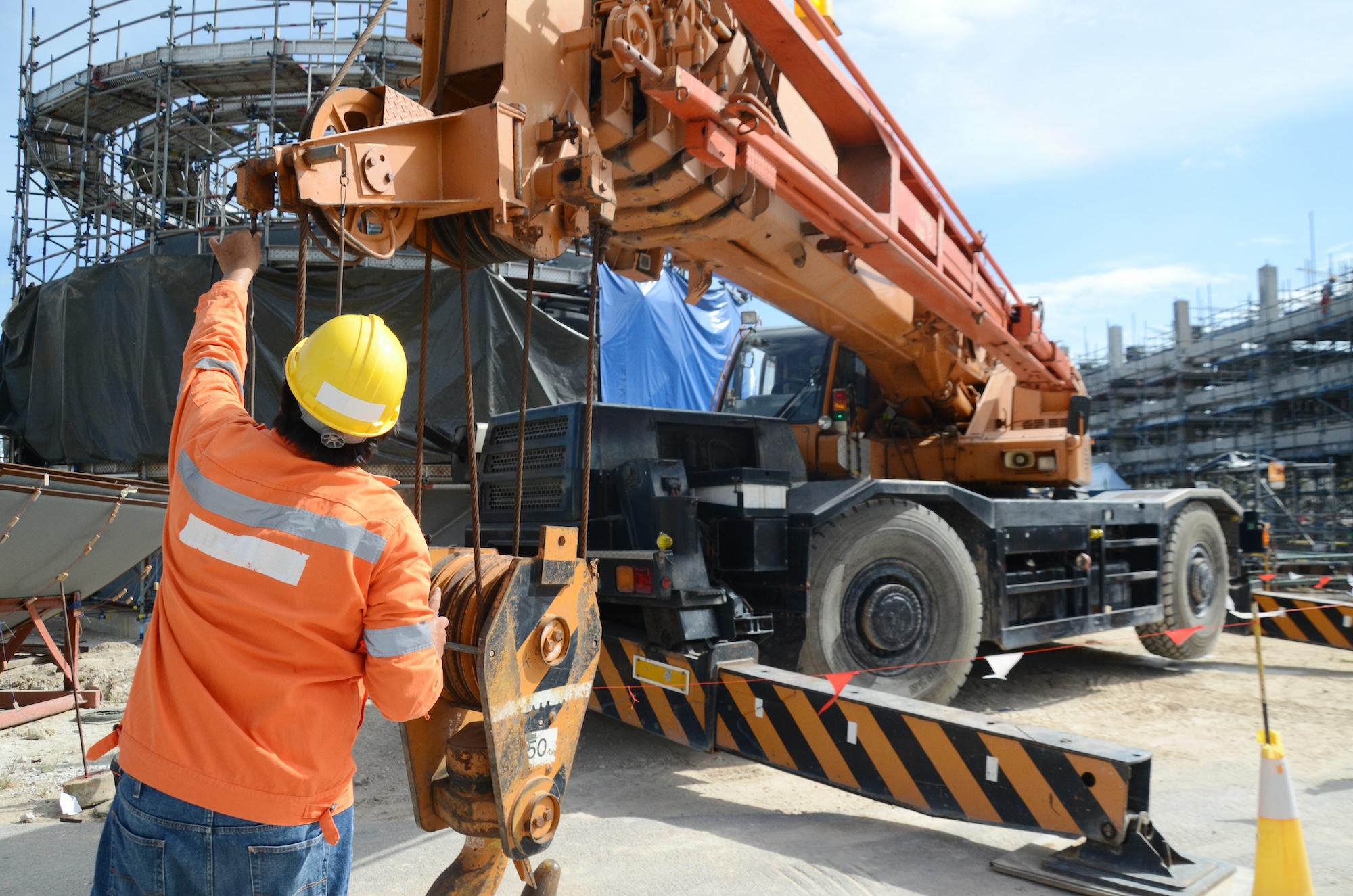 Crane operator conducting safety inspecting on the wire sling which attached with crane lifting hook prior completed his daily work construction site